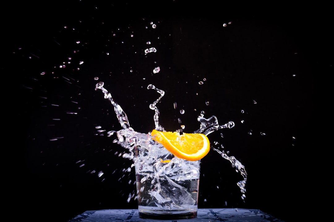 splash of water in drinking glass with sliced lemon splash of water in drinking glass with sliced lemon