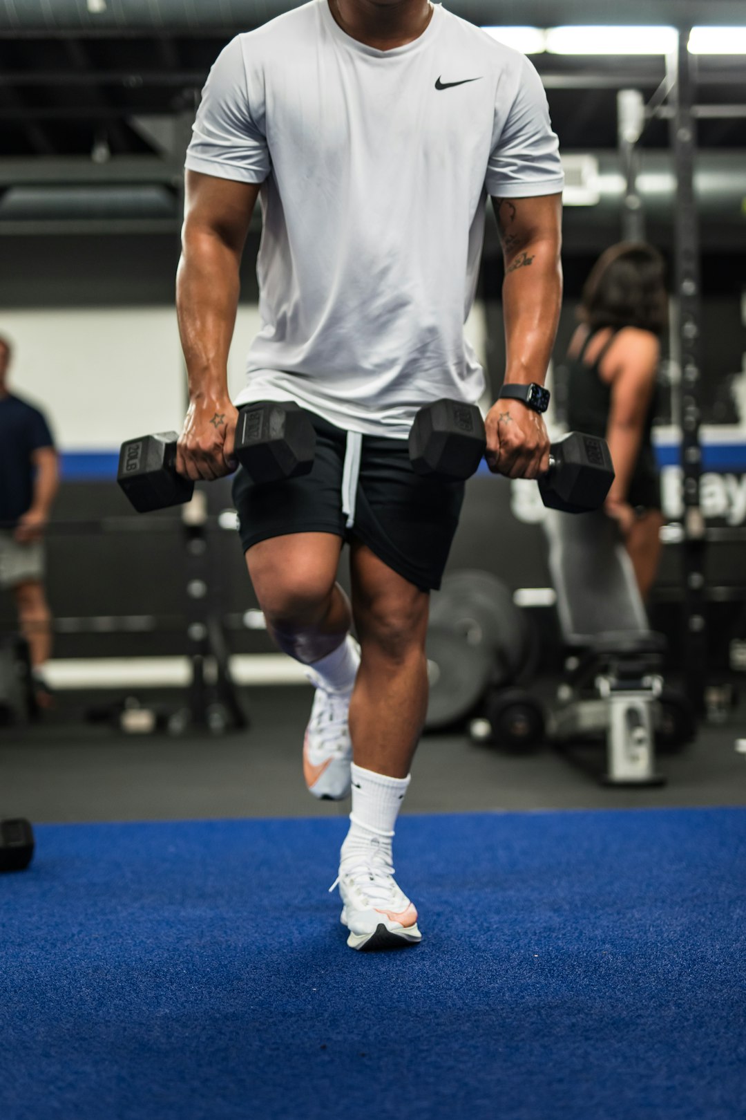 man in gray tank top and black shorts holding black dumbbell man in gray tank top and black shorts holding black dumbbell