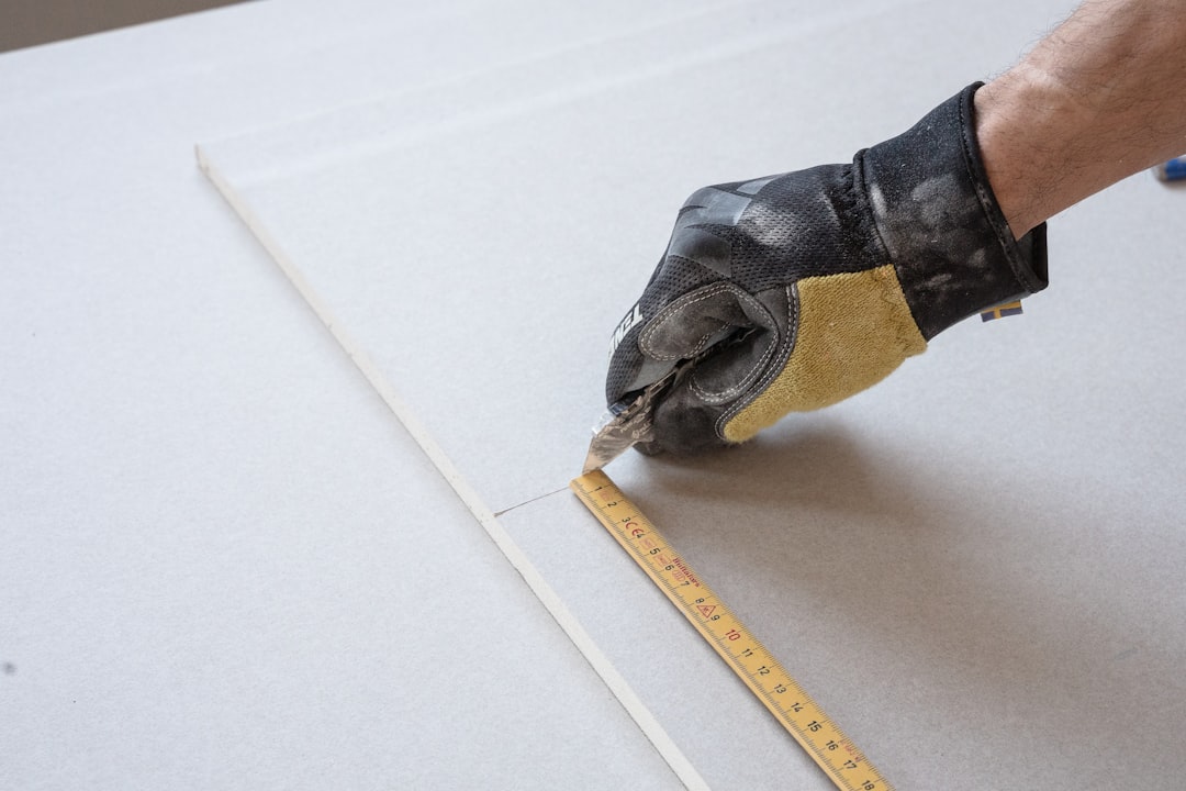 a person measuring a piece of paper with a tape a person measuring a piece of paper with a tape