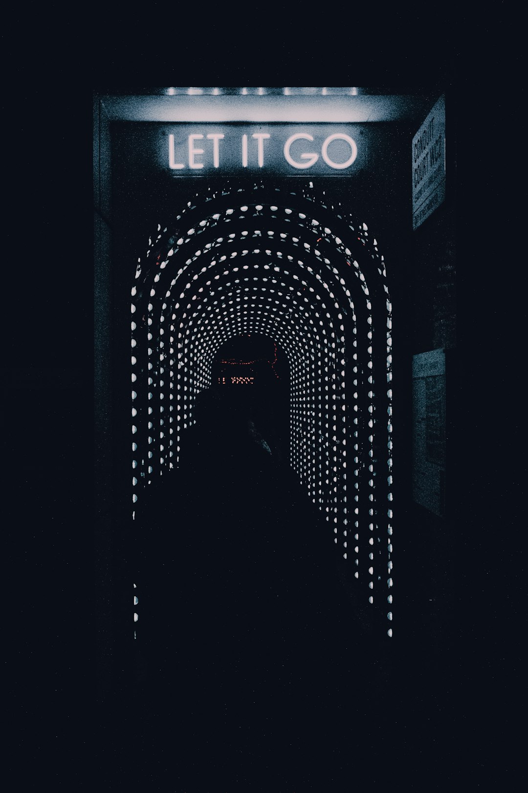 a dark tunnel with a sign that says let it go a dark tunnel with a sign that says let it go