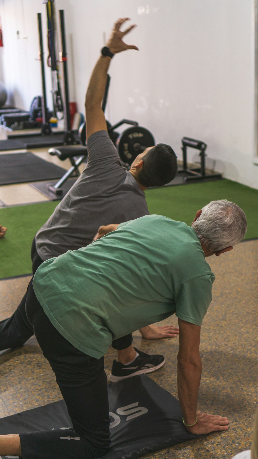 a couple of men standing on top of a yoga mat a couple of men standing on top of a yoga mat
