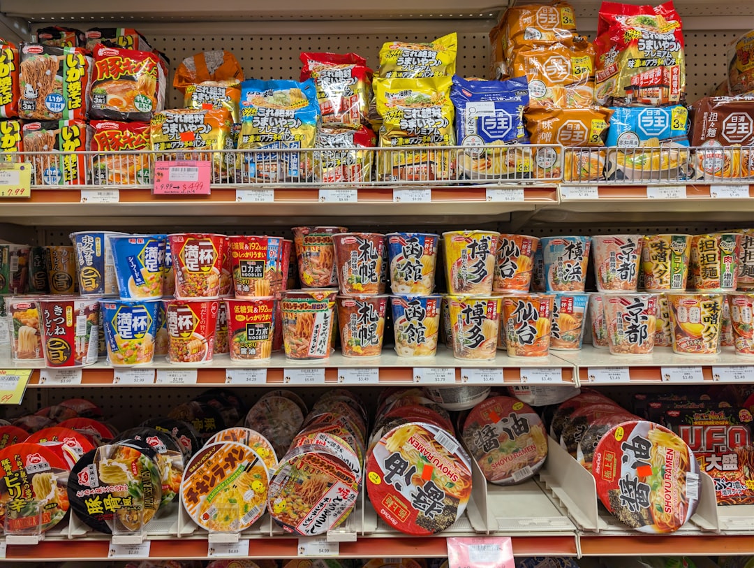 Shelves stocked with various instant noodle cups and snacks.
